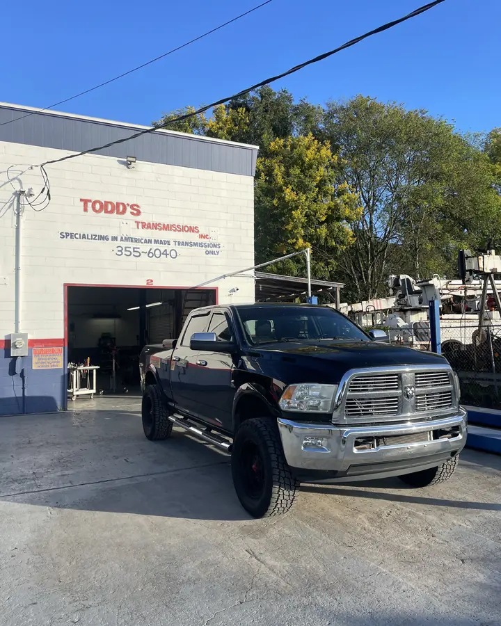 Black Ram heavy-duty pickup parked in front of the Todd's Transmissions shop