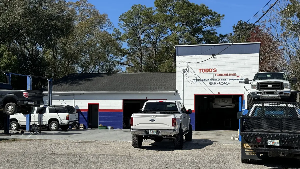 Todd's Transmissions shop on Wacissa Ave with pickups out front and the painted sign: Specializing in American Made Transmissions Only