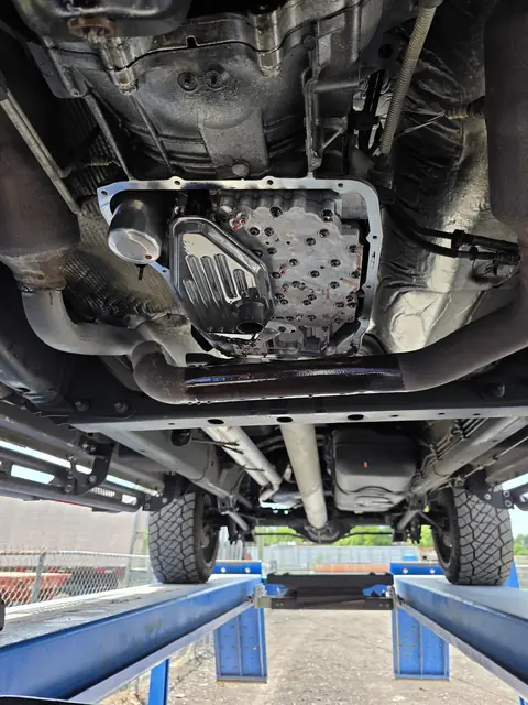 Underside of a pickup on the lift with the transmission pan off and the valve body showing